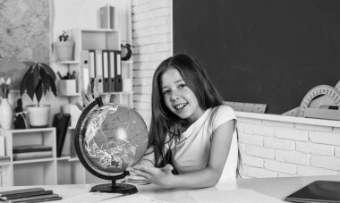 Coğrafya. Okula dönüyorum. Modern hayatta resmi eğitim. Evde eğitim kavramı. Çocukluk gelişimi. İnceleme yoluyla bilgi edinmek. Sınıfta tahtası olan bir çocuk. Çocuk küreye bak.