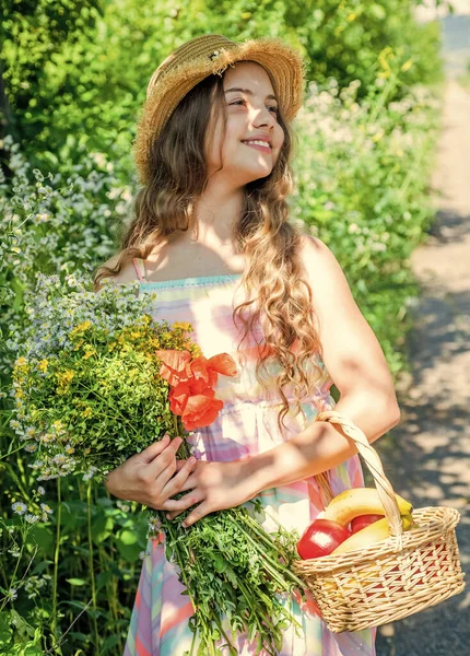 Девочка в саду держит корзину с фруктами и цветами, экожизнь — стоковое фото
