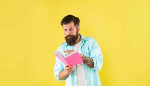 Zaneprázdněný hipster chlap čtení notebook na žlutém pozadí, erudice — Stock fotografie