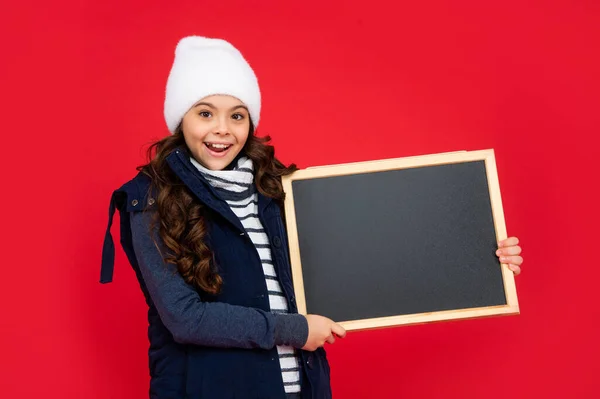 Menina adolescente surpreso segurando quadro com espaço de cópia. criança de volta à escola. anúncio — Fotografia de Stock