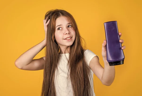 Linda niña tiene un peinado de moda y usar loción en botella, producto de belleza — Foto de Stock