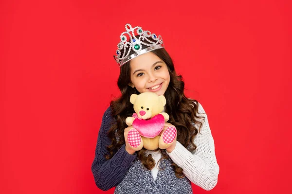 Позитивна дитина в короні королеви. принцеса в тіарі. дитина тримає іграшку ведмедя. дівчина-підліток носить діадемію — стокове фото