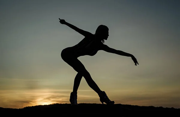 Baletka. žena silueta na pozadí oblohy. pocit svobody. ženskou siluetu při západu slunce. žena tančí za úsvitu. tmavá postava tanečnice. Večer tančí. stín a stín — Stock fotografie