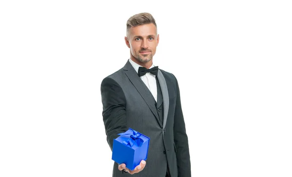Sonriente hombre en esmoquin y pajarita sujetar presente caja aislada sobre fondo blanco — Foto de Stock