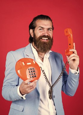 Formalite icabı giyinmiş bir adamın sakalı vardır. Retro telefon kullan, ara.