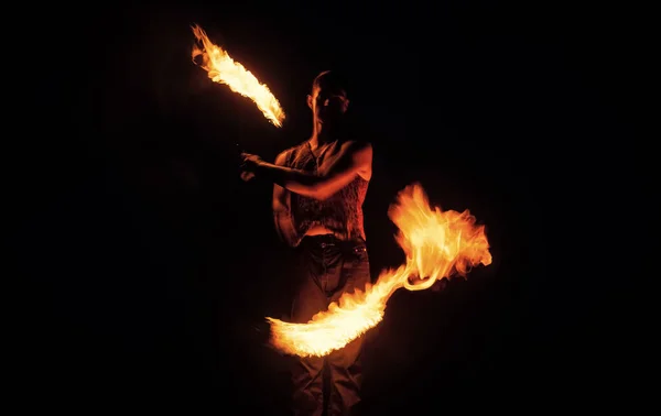 Fakir show. Happy man manipulate with burning poi. Fire fakir perform dangerous tricks.