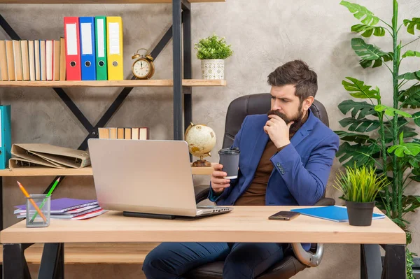 Σκέψη βάναυση CEO σε επιχειρηματικό κοστούμι με pc και καφέ στο γραφείο, σύγχρονη ζωή — Φωτογραφία Αρχείου