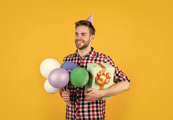 Şık saçlı, sakallı, balonları ve kutuları olan bir erkek. — Stok fotoğraf