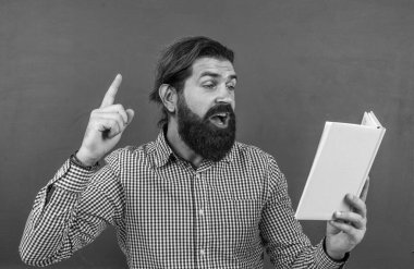 gayri resmi eğitim. Erkek öğrenci ders sırasında sınıfta oturur. Sınavı geç. Konuyu öğrenmek. Okula dönüyorum. Öğretmenler günün kutlu olsun. Sakallı acımasız adam kitap tutuyor. edebiyat ve okuma