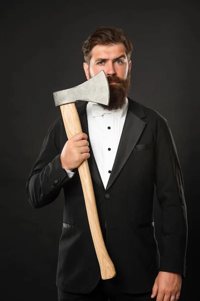 Homem barbudo sério em terno formal segurando machado em face raspada fundo escuro, barbearia — Fotografia de Stock