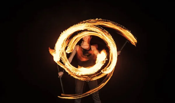 Dişi ateş dansçısı yanan sopayı çeviriyor hareket halinde parlak izler yaratıyor. — Stok fotoğraf