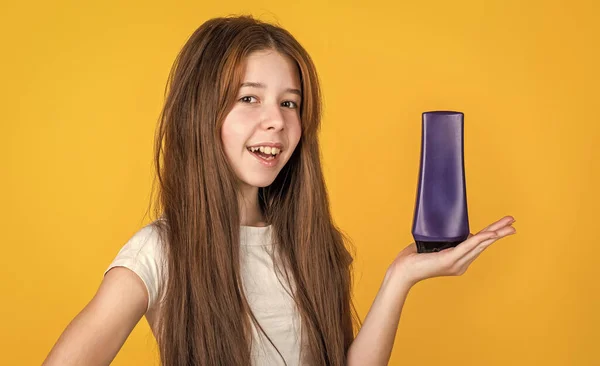 Menina alegre com longo cabelo liso segurar condicionador xampu ou garrafa de gel, banho — Fotografia de Stock
