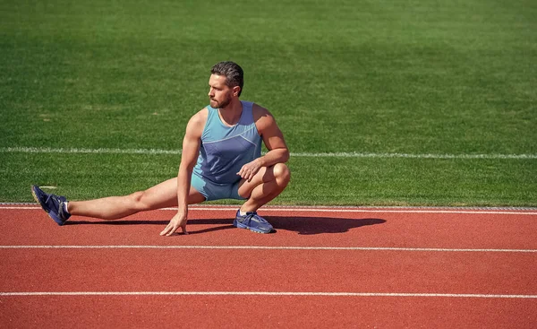Volwassen man stretching zijn benen voor een stadion workout, stretch — Stockfoto