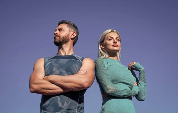 Självsäkra sportpar. Muskulös man och sexig kvinna i sportkläder. idrottare människor känner framgång. — Stockfoto