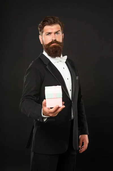 Man met baard in smoking strikje formele slijtage op zwarte achtergrond met doos. verjaardag — Stockfoto