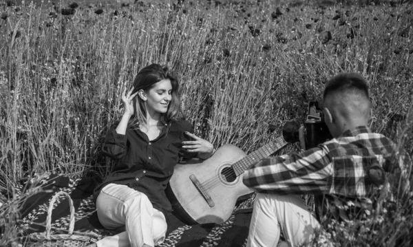 Couple romantique dans un champ de pavot faire des photos sur la caméra un jour d'été, photographier — Photo