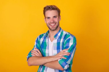 Kendine güvenen bir gülümseme. Özgüvenli adam sarı arka plan portresi. Gülümseyen güven