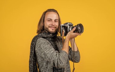 Profesyonel fotoğrafçı. Yeni yıl tatili ve tatil. Erkekler için örgü giysisi. Fotoğraf makinesi olan neşeli bir adam. Kışın fotoğraflarını çekmeyi seviyorum. Gülümse. Hadi bir atış yapalım.