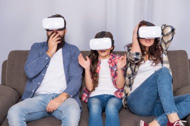 Çocuklu mutlu ebeveynler modern teknolojiyi kullanır. Anne, baba ve kızı..