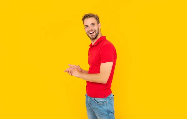 Glad unshaven young man in red shirt on yellow background, casual — Stock Photo, Image