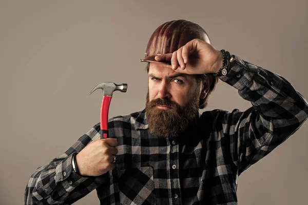 Hipster masculino barbudo em camisa quadriculada e capacete operário, trabalhando — Fotografia de Stock