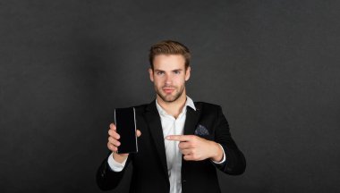 Mobil aygıtı işaret eden profesyonel yönetici. Karanlık arkaplan kopyalama alanı, telefon.
