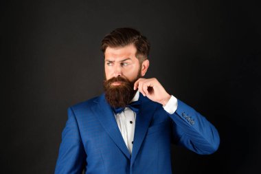 Smokin papyonlu lüks bir adam. Siyah arka planda resmi giyinen bir adam. erkek resmi moda