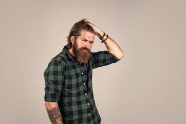 Sıradan moda tarzı. Modern görünümlü sakallı hippi. Kuaför konsepti. Bıyıklı vahşi yakışıklı adam. Stüdyo geçmişinde olgun bir berber. erkeklik ve karizma