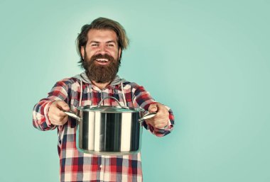 Yemek hazır. Bıyıklı sakallı adam mutfak aletleri kullanıyor. Sağlıklı yemek. Yapışmayan yüzey. Şef yemek yapıyor. Tavalı kareli gömlekli olgun bir adam. Şık erkek yemek pişirecek.