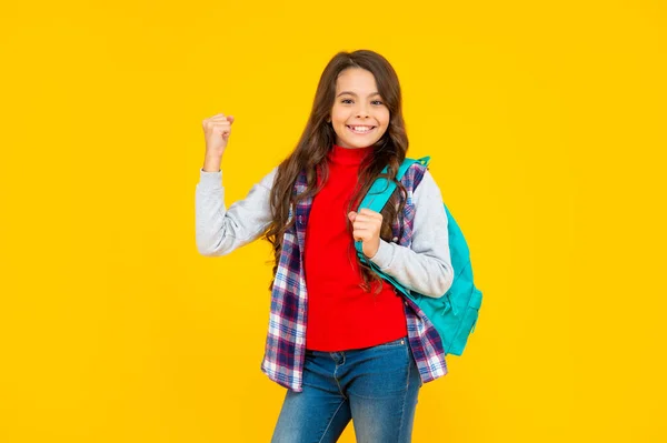 Chica adolescente alegre en ropa casual sosteniendo el bolso de la escuela sobre fondo amarillo, universidad — Foto de Stock