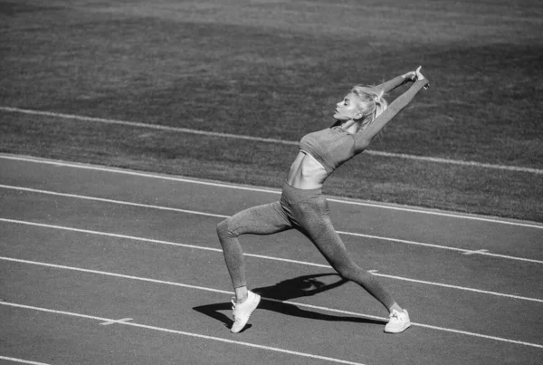 Full of energy. athletic lady warming up on stadium running track. female athlete do sport workout — Stock Photo, Image