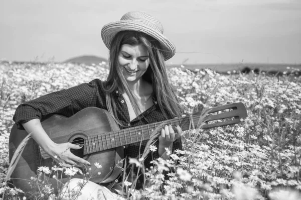 Femme heureuse recueillir des fleurs en été marguerite terrain jouer guitare acoustique, campagne — Photo