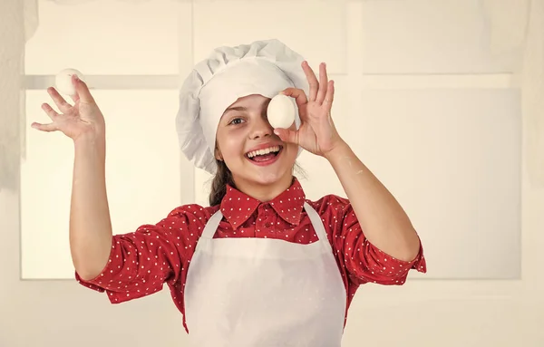 Веселая девочка готовит домашнюю выпечку, яйцо — стоковое фото