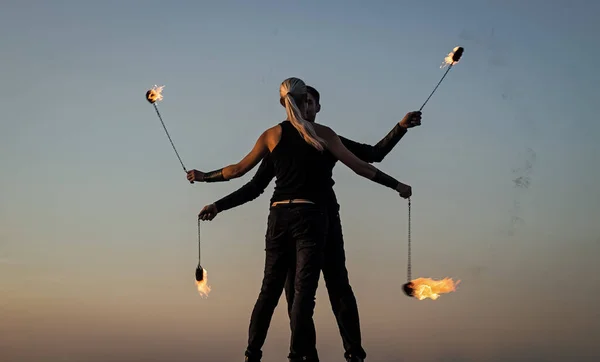 Para w miłości taniec podczas przędzenia płonące poi błękitne niebo na zewnątrz, pokaz ognia — Zdjęcie stockowe