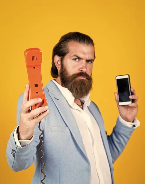 Hombre barbudo maduro buscando elegante bodega retro y teléfono moderno, elección — Foto de Stock