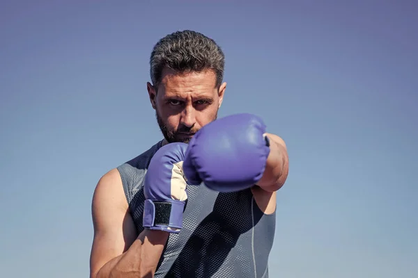 Boxeador hombre golpeando. gimnasio gimnasio al aire libre. musculoso atlético chico entrenamiento en guantes de boxeo —  Fotos de Stock