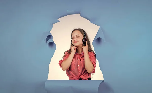 Stylové dítě dívka hledá trendy v moderní sluchátka, ebook — Stock fotografie