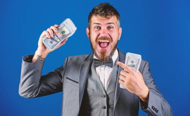 Nakit kolay ve hızlı bir şekilde olsun. Nakit işlem iş. Adam mutlu kazanan zengin doları banknot yığını mavi arka plan tutun. Kolay nakit krediler. Piyango kavramı kazanmak. İşadamı nakit para var.