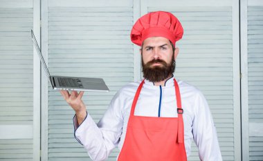 Mutfakta şef dizüstü bilgisayar. Aşçılık okulu. Hipster şapka ve önlük ürünleri online satın almak. Online alışveriş. Teslimat hizmeti. Adam şef yiyecek pişirme online malzemeler arıyor. Bakkal dükkanı çevrimiçi