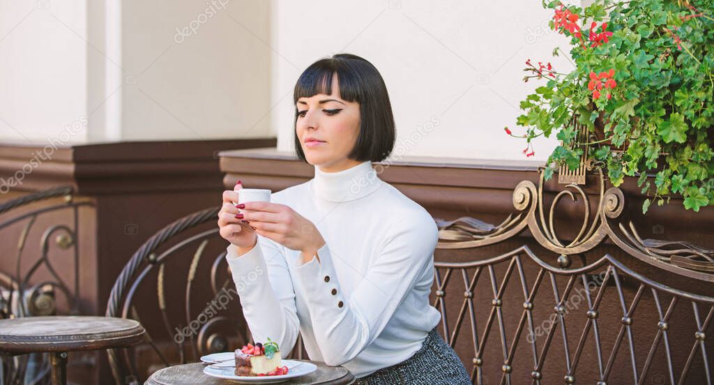 Dessert concept. Pleasant time and relaxation. Delicious and gourmet snack. Girl relax cafe with coffee and dessert. Woman attractive elegant brunette enjoy dessert and coffee cafe terrace background