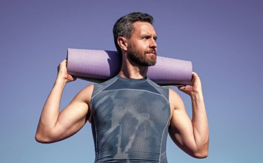 Atletik kaslı adam yoga minderi ve formda.