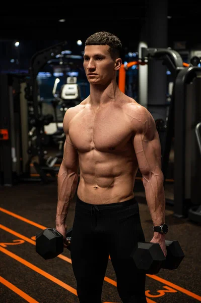 Póló nélküli testépítő férfi csinál súlyzó edzés tornaterem, testépítés — Stock Fotó