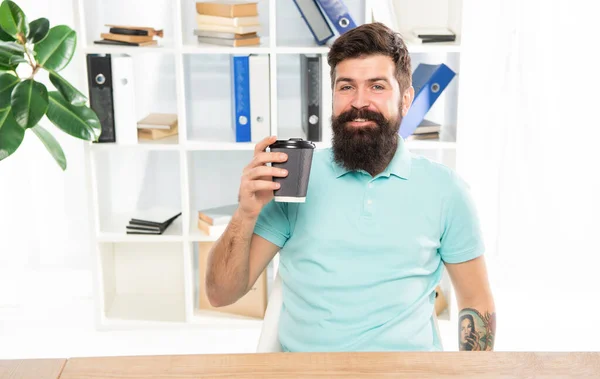 Happy man holding takeaway coffee cup sitting in office, coffee break — Stock Photo, Image
