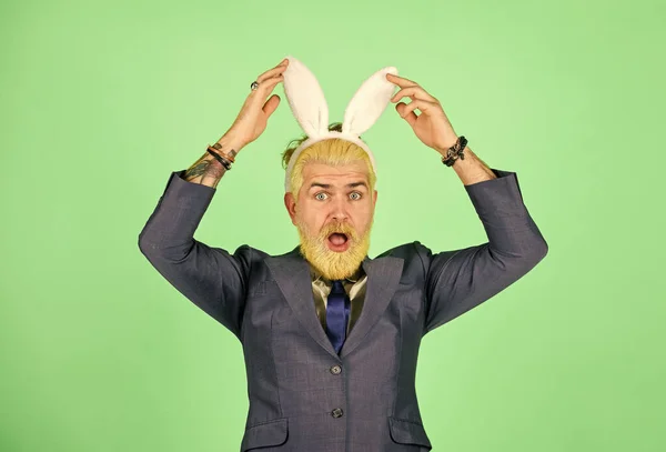 Voorjaarsvakantie. Zakenman dragen konijnenkostuum accessoire. Een man met een baard raakt konijnenoren aan. Paasfeest en plezier. Voorjaarsseizoen. Lente equinox vieren. De lente is hier. — Stockfoto