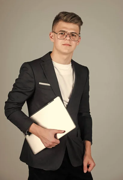 Genç çocuk resmi takım elbise giyiyor ve gözlük takıyor dizüstü bilgisayar kullanıyor. — Stok fotoğraf