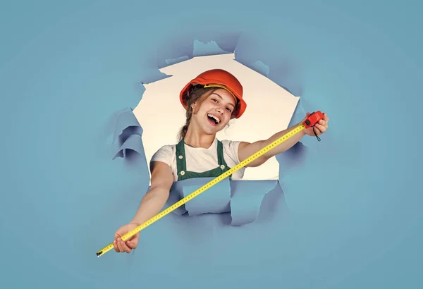 Cheerful child laborer using building uniform and tape measure, measurement — Stock Photo, Image