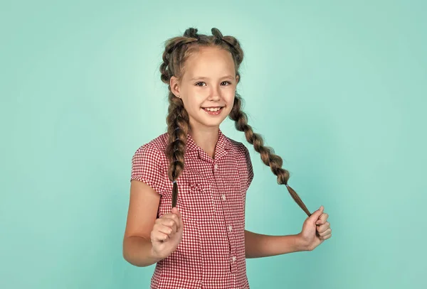 Happy girl has beautiful hairstyle. kid with braided hair. child with nice smile. female hairdresser salon. beauty and fashion. childhood happiness. looking stylish and trendy — Stock Photo, Image