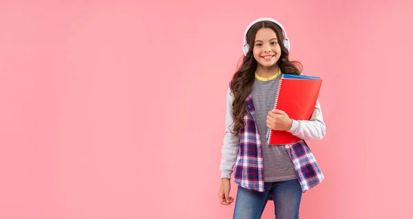 현대의 이어폰을 사용하는 행복 한 아이는 작업 책을 가지고 있습니다. 온라인 교육. 다시 학교 로. — 스톡 사진