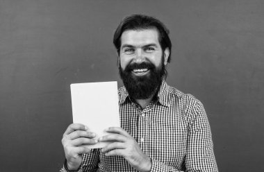 Gelmiş geçmiş en iyi kitap. Konuyu öğrenmek. Kitabı gösteren sakallı mutlu adam. öğrenim süreci. Resmi olmayan eğitim. Edebiyat dersi sınıfında erkek öğrenci. Sınavı geç.