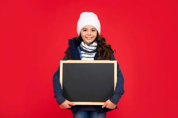 Tersenyum anak kembali ke sekolah. Pengumuman dan iklan. Penjualan musim dingin. anak memegang papan tulis — Stok Foto